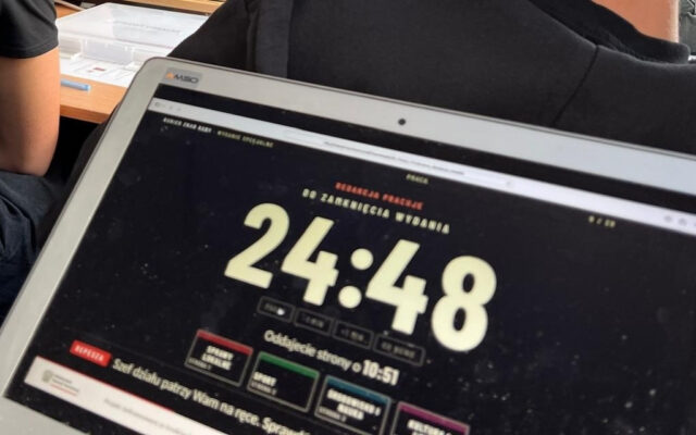 Laptop z zegarem redakcji: „Do zamknięcia wydania 24:48”, „Oddajecie strony o 10:51”, cztery działy gazety i depesza „Szef działu patrzy Wam na ręce”