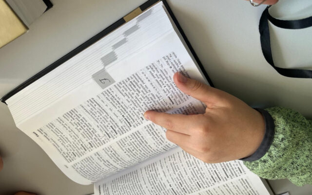 Ręka ucznia na otwartym słowniku języka polskiego, na stronie z hasłami na literę F